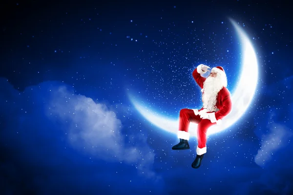 Foto de Papai Noel sentado na lua — Fotografia de Stock