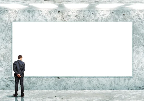 Business person standing near a blank billboard — Stock Photo, Image