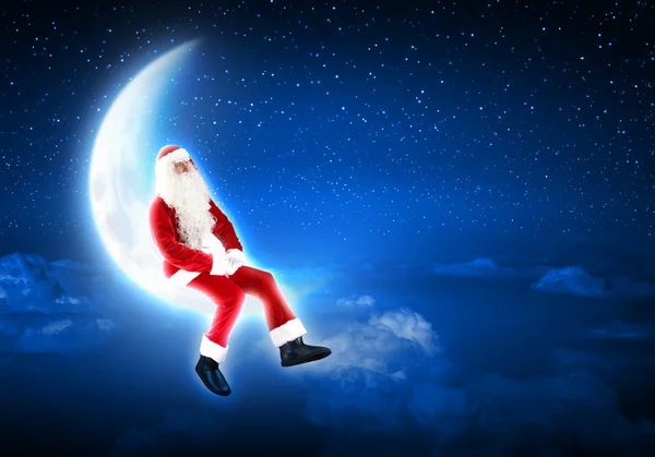 Foto de Papai Noel sentado na lua — Fotografia de Stock