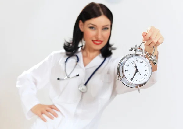 Young female doctor with clocks — Stock Photo, Image