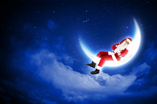 Foto de Papai Noel sentado na lua — Fotografia de Stock