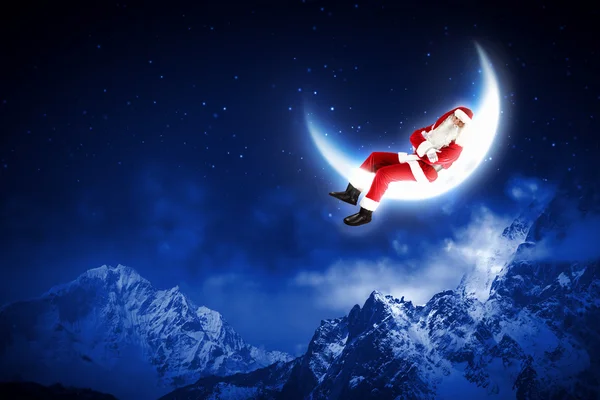 Foto van santa claus zittend op de maan — Stockfoto