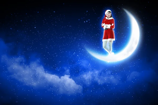 Photo of santa girl sitting on the moon — Stock Photo, Image