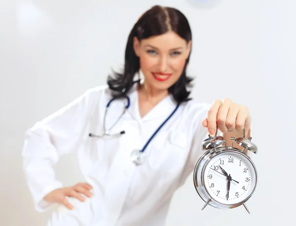 Young female doctor with clocks — Stock Photo, Image