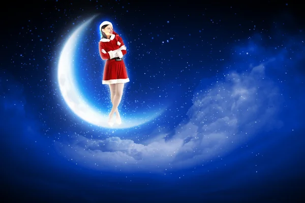 Foto van santa meisje zittend op de maan — Stockfoto