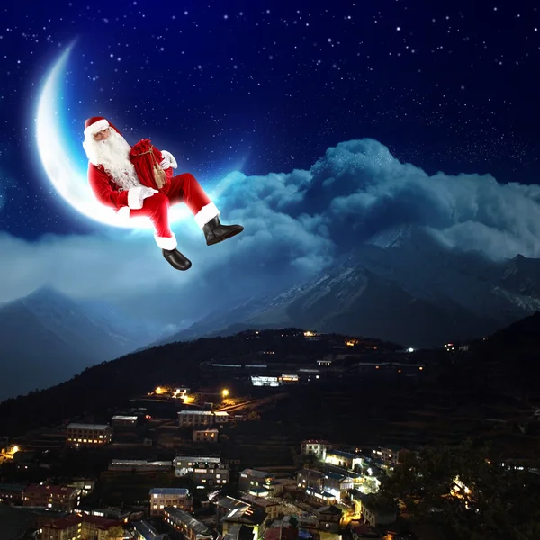 Фото Санта-Клауса, сидящего на Луне — стоковое фото