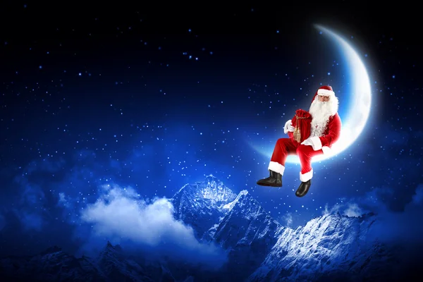 Foto de Papai Noel sentado na lua — Fotografia de Stock