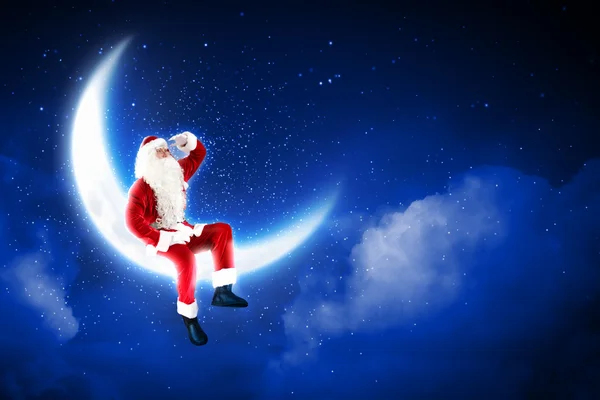 Foto de Papai Noel sentado na lua — Fotografia de Stock