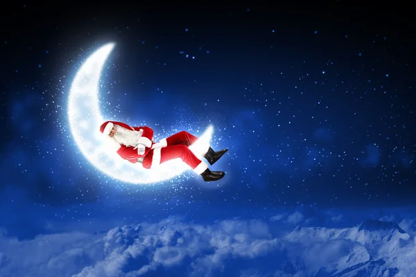 Foto van santa claus zittend op de maan — Stockfoto