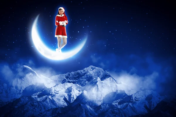 Photo of santa girl sitting on the moon — Stock Photo, Image