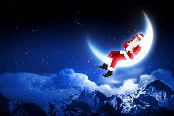 Foto de Papai Noel sentado na lua — Fotografia de Stock