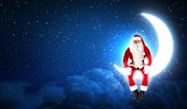 Foto de Papai Noel sentado na lua — Fotografia de Stock