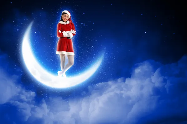 Photo of santa girl sitting on the moon — Stock Photo, Image