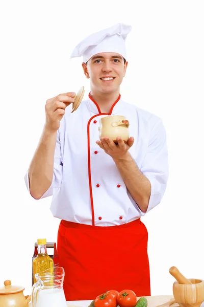 Jovem cozinheiro preparando alimentos usando um avental vermelho — Fotografia de Stock