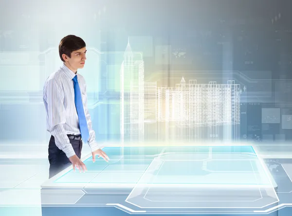 Young businessman looking at high-tech image of building model — Stock Photo, Image