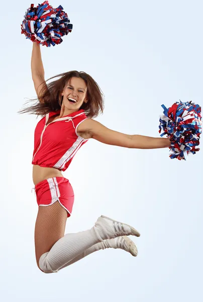 Young beautiful female cheerleader in uniform jumping high — Stock Photo, Image