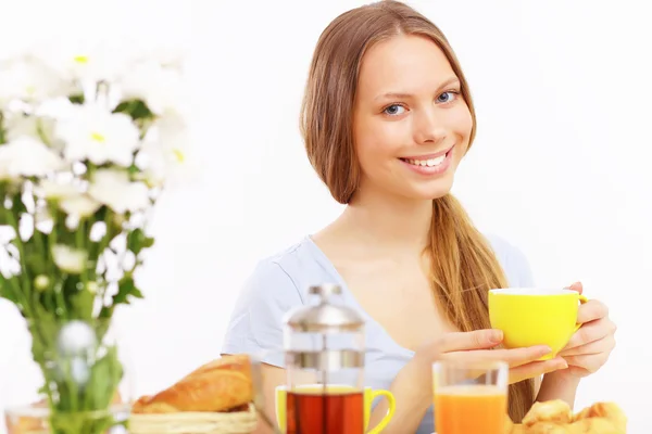Beautiful young woman drinking tea from yellow cup — Stock Photo, Image