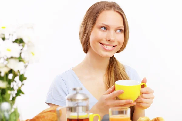 Bella giovane donna che beve tè dalla tazza gialla — Foto Stock