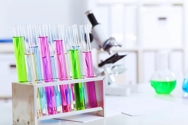 Chemistry laboratory glassware with colour liquids in them — Stock Photo, Image