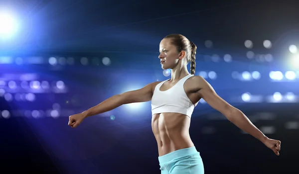 Fitness vrouw stond tegen achtergrond verlichting in kleur — Stockfoto