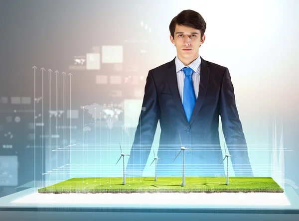 Image of young businessman looking at high-tech picture of windmills — Stock Photo, Image