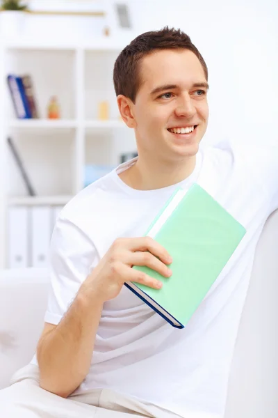 Young handsome man at home with a book — Stock Photo, Image