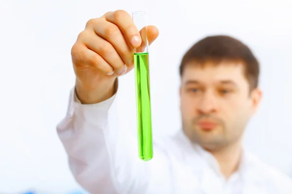 Joven científico masculino trabajando con líquidos en laboratorio —  Fotos de Stock