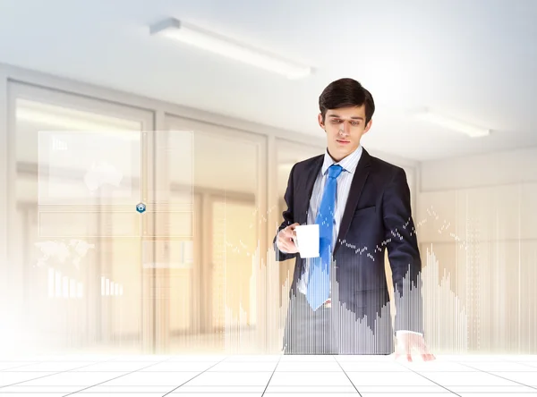 Young businessman looking at graph of high-tech image — Stock Photo, Image