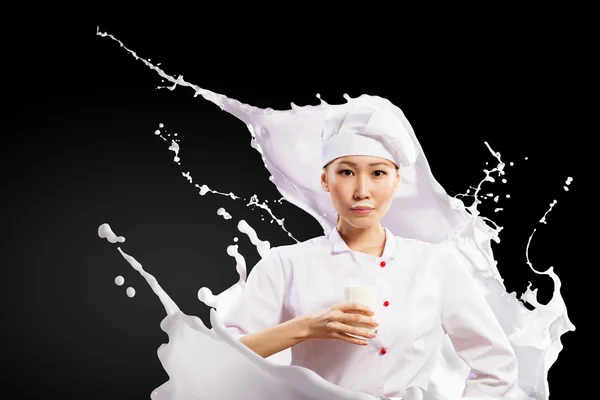 Aziatische vrouwelijke cook tegen melk spatten — Stockfoto