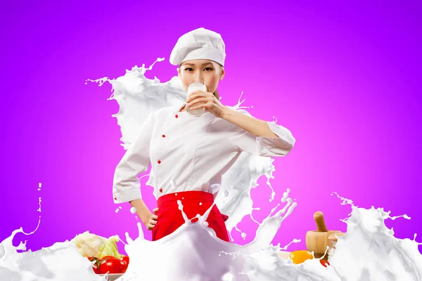 Asiatico femmina cuoco contro latte schizzi — Foto Stock