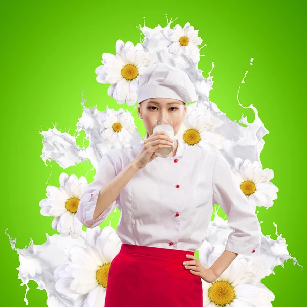 Asian female cook against milk splashes — Stock Photo, Image