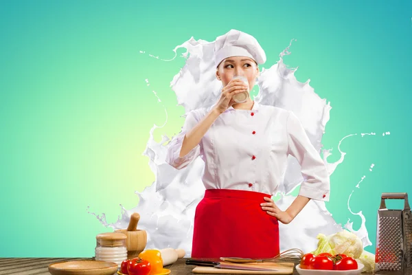 Asiático cozinheiro feminino contra salpicos de leite — Fotografia de Stock