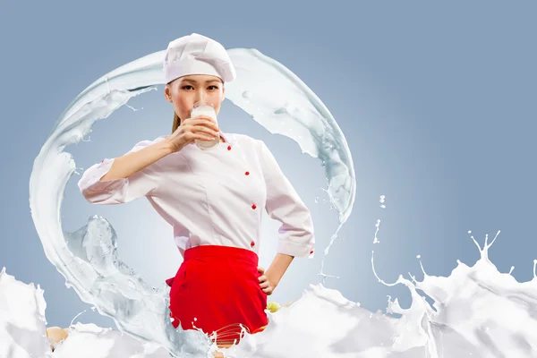Asiatiska kvinnliga kock mot mjölk stänk — Stockfoto