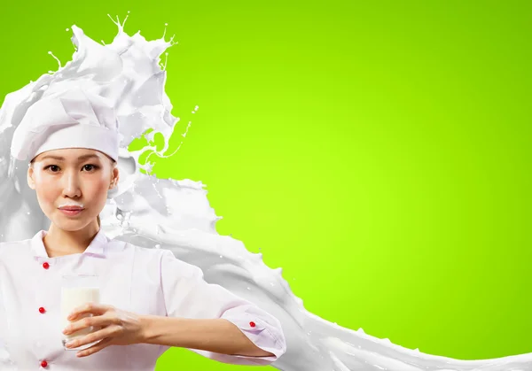 Asian female cook against milk splashes — Stock Photo, Image