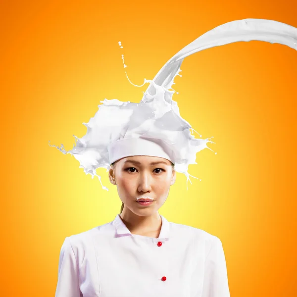 Asiatique femelle cuisinier contre lait éclaboussures — Photo