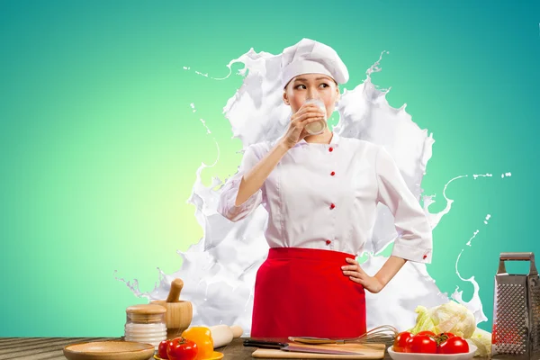 Азиатская кухарка против брызг молока — стоковое фото