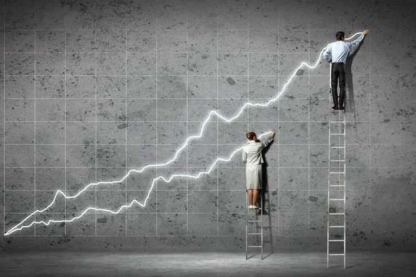 Businesspeople drawing diagrams on wall — Stock Photo, Image