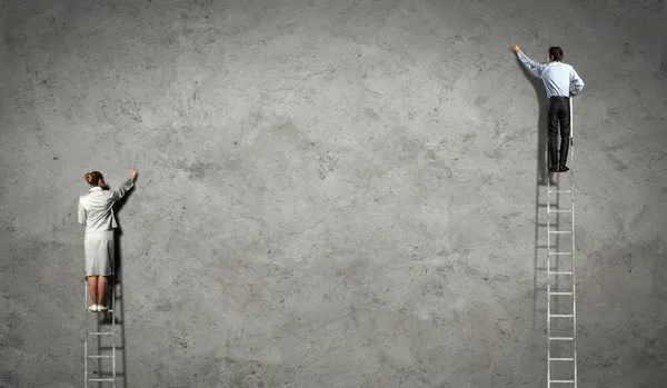 Businesspeople drawing diagrams on wall — Stock Photo, Image