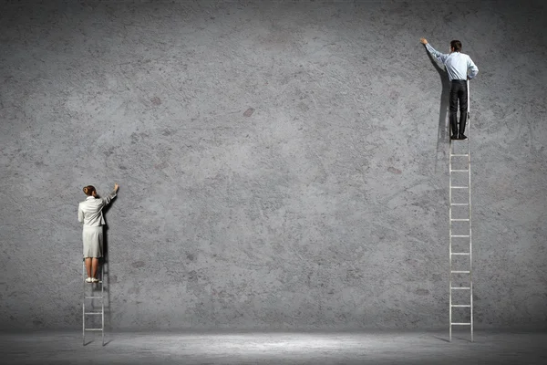 Empresarios dibujando diagramas en la pared — Foto de Stock