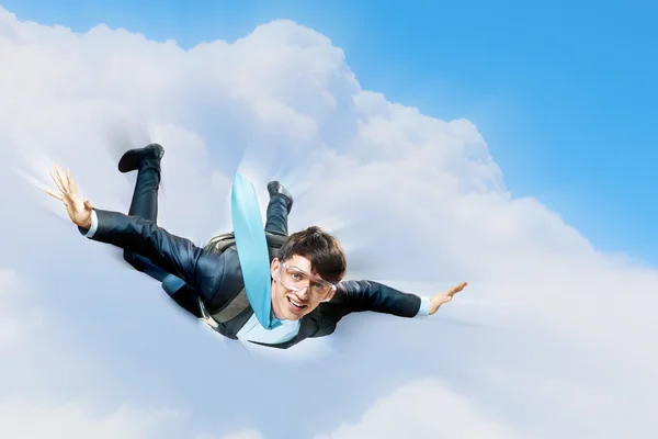 Jeune homme d'affaires volant avec parachute sur le dos — Photo