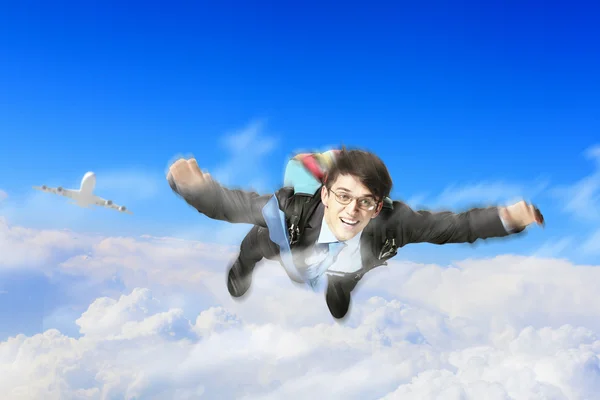 Jovem empresário voando com paraquedas nas costas — Fotografia de Stock