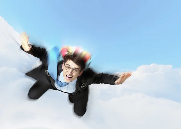 Mladý podnikatel létání s padákem na zádech — Stock fotografie