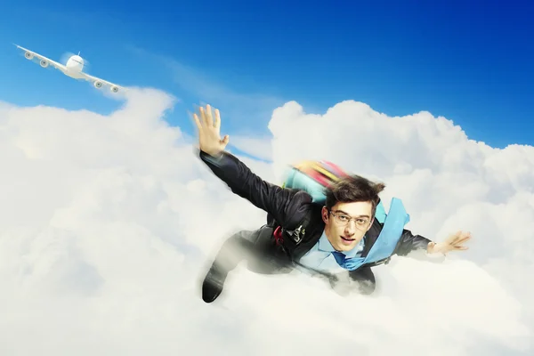 Ung affärsman flyger med fallskärm på ryggen — Stockfoto