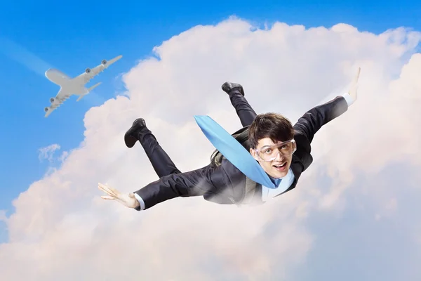 Jeune homme d'affaires volant avec parachute sur le dos — Photo
