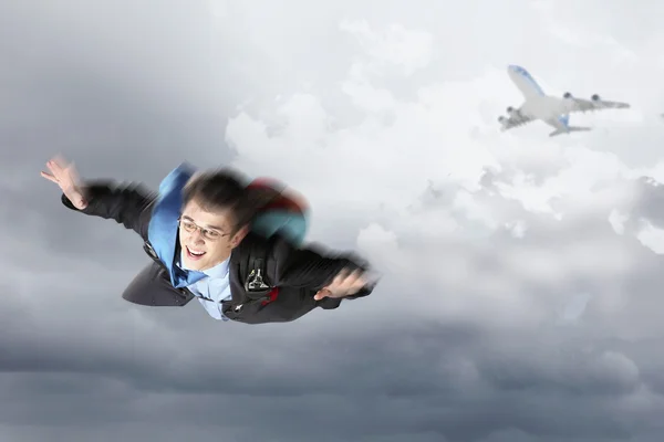 Giovane uomo d'affari che vola con paracadute sul retro — Foto Stock
