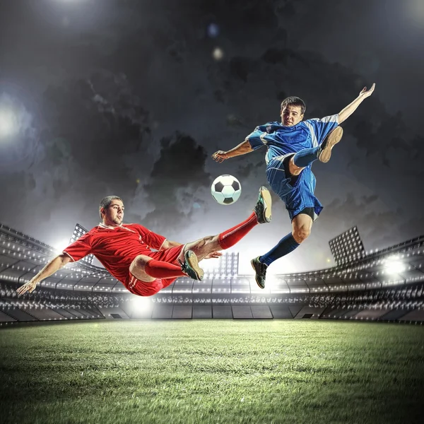 Dois jogadores de futebol golpeando a bola — Fotografia de Stock