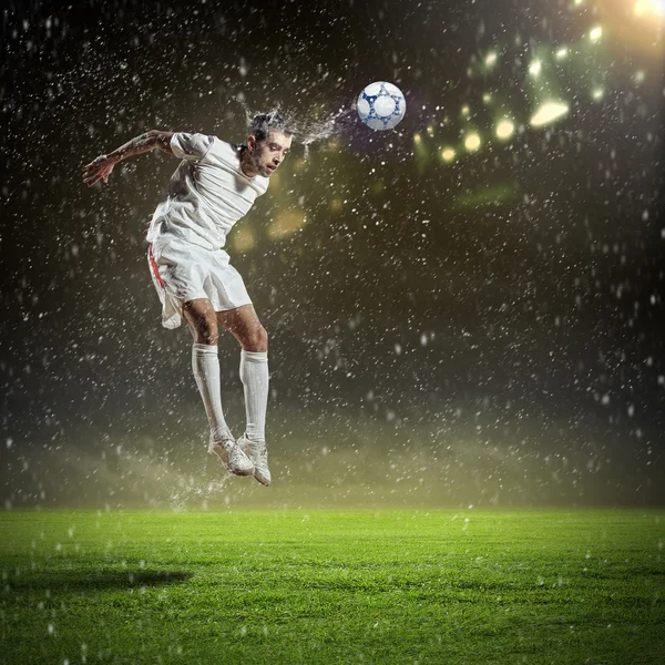 Jogador de futebol golpeando a bola — Fotografia de Stock