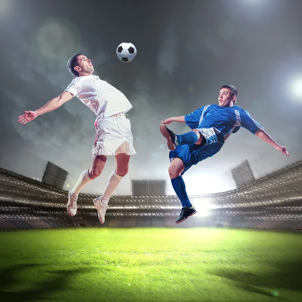 Two football players striking the ball — Stock Photo, Image