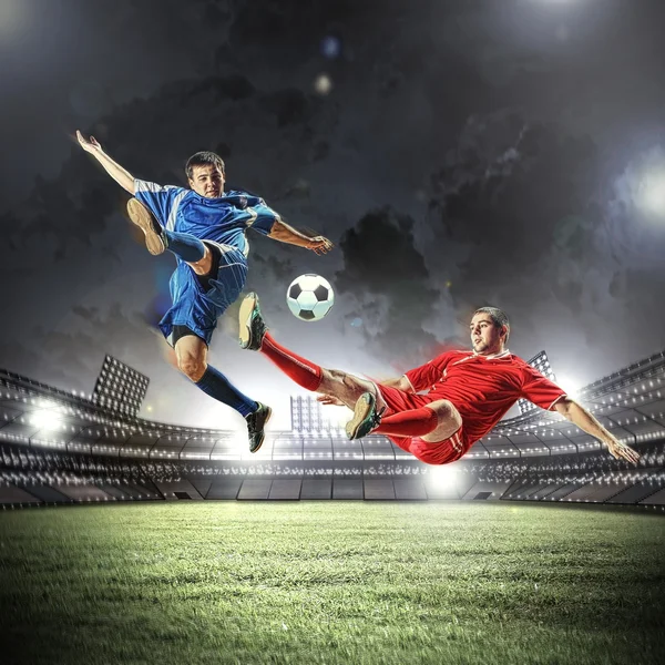 Two football players striking the ball — Stock Photo, Image