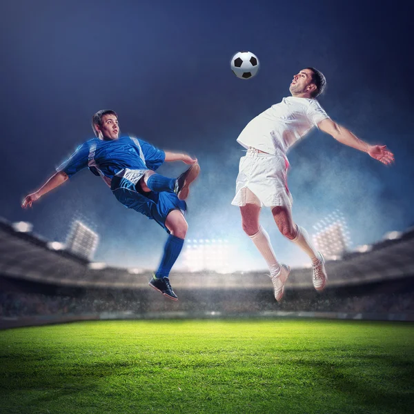 Dos jugadores de fútbol golpeando la pelota — Foto de Stock